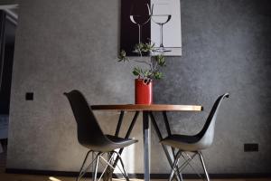 卢茨克Дизайнерські апартаменти в ЖК DreamTown 10б的一张桌子,两把椅子和一个花瓶