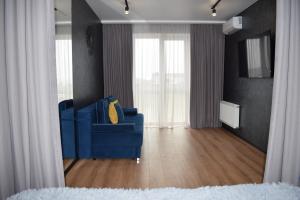 卢茨克Дизайнерські апартаменти в ЖК DreamTown 10б的客厅配有带窗帘的蓝色沙发