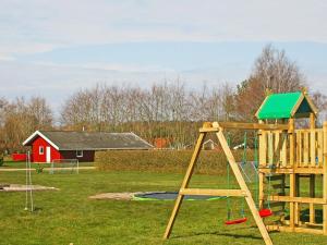 诺德堡12 person holiday home in Nordborg的一个带木制秋千的游乐场