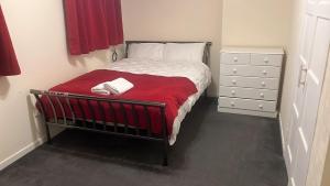 阿伯丁Homie的一间卧室配有一张带红色毯子的床和梳妆台