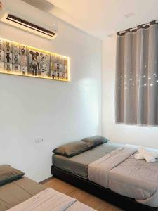 马六甲Dato Villa Luxury Homestay 12min to Jonker Street 26pax Private Pool的一间卧室设有两张床和一个带窗帘的窗户。
