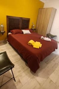 CampinhoAladin Comfort Country Rooms的一间卧室配有一张大床,床上配有黄色毛巾