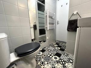 布尔日Logement Neuf - Proximité Centre的浴室设有卫生间,铺有黑白瓷砖地板。
