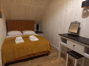 米尔科Domek Relaks pod Śnieżką的一间卧室配有床和一张带毛巾的书桌