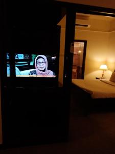 吉隆坡Ts service suites at Times Square的女人在旅馆房间电视机上