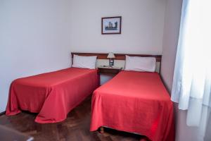 圣达菲Castelar Hotel Santa Fe的红色床单的客房内的两张床