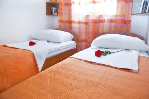 杜布罗夫尼克一流美景公寓的两张床铺,房间上挂着两朵玫瑰