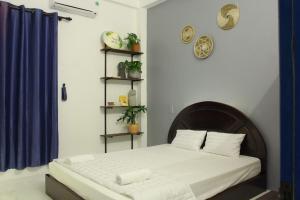 会安Dom Hostel and Bar的一间卧室设有一张床和蓝色的墙壁