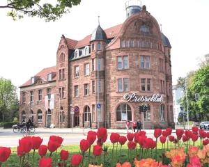 爱尔福特BohnApartments Altstadt-Loft - Wasserbett - gratis Parkplatz - WLAN - Zentrum的一座大砖砌建筑,前面有红花