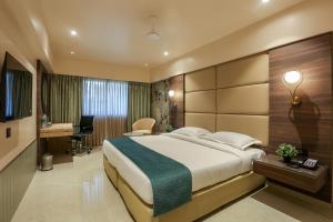纳威孟买Hotel Corporate的酒店客房设有一张大床和一张书桌。