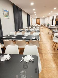 哈卡Hotel Acebo Plaza Mayor的配有桌子和白色椅子的大房间