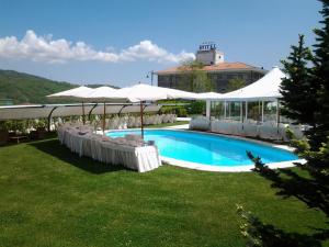 卡斯泰尔佩特罗索拉丰特戴拉斯托雷酒店的一座带白色遮阳伞的游泳池和一座建筑