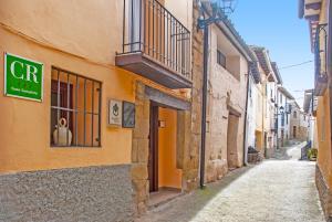 里格洛斯Casa Barranquero的一条黄色建筑的小巷,上面有标志