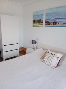 巴雷罗斯Apartamento Oceano的白色卧室配有白色的床和梳妆台