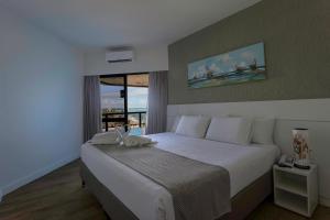 马塞约马塞约大西洋套房酒店的卧室设有一张白色大床和一扇窗户。