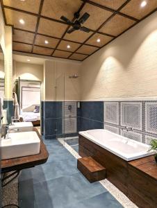 阿姆利则Cape House的大型浴室设有两个盥洗盆和浴缸。