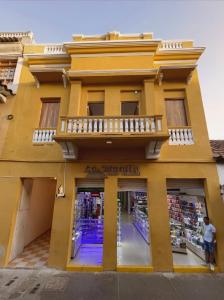 卡塔赫纳Hostal Casa Torres Centro Historico - Adults Only的黄色建筑前的商店