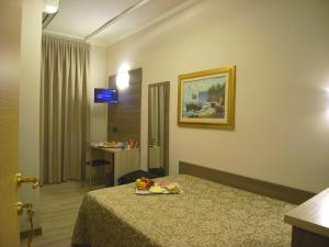 米兰锡耶纳酒店的酒店客房的床铺上装有果盘