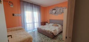 索里根安诺沃Andrea affittacamere e B&B的一间卧室拥有橙色的墙壁、一张床和窗户