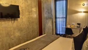 巴拿马城Hotel Casa Panama的一间卧室配有一张床和一台平面电视