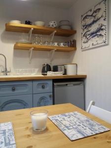 WhitwellThe Bake House (Berryl Farm Cottages)的厨房配有蓝色橱柜和木桌