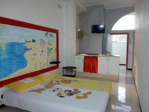 韦列Casavacanze Salento Gramsci的卧室配有一张床,墙上挂有绘画作品