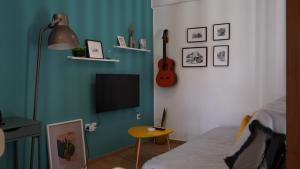 沃尼扎Luxury Studio in Vonitsa的客房设有床、电视和桌子。