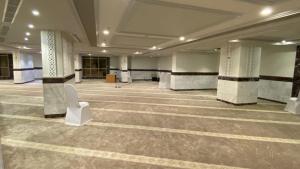 麦加فندق منار التوحيد 2的大房间设有圆柱和白色椅子