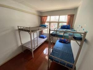 曼谷Sura Hostel and Coworking的客房设有两张双层床和一扇窗户。
