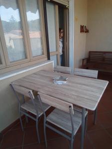 马西亚娜马里纳Appartamento Loretta的窗户客房内的一张木桌和椅子