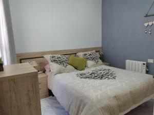 格罗韦Vistas Al Mar E Isla De La Toja的一间卧室配有一张带书桌和枕头的床。