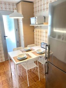 EspinardoGuest house Croqueta Espinardo的厨房配有桌椅和冰箱。
