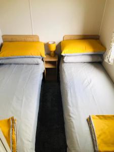 新罗姆尼Cosy holiday home at Romney Sands的两张睡床彼此相邻,位于一个房间里