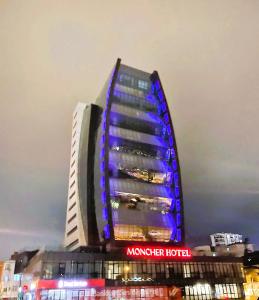 图兹拉Moncher Hotel的建筑的侧面有蓝色的灯光