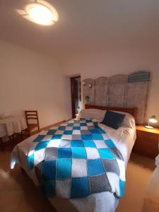 圣地亚哥-杜卡森Casa do Moleiro的一间卧室配有一张带蓝色和白色棉被的床