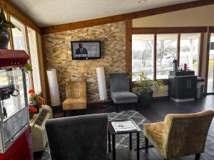华盛顿Rodeway Inn的客厅配有椅子和砖墙上的电视
