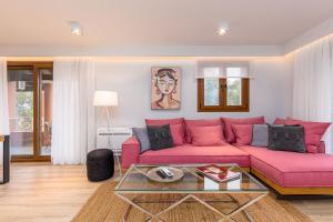 里亚帕德斯Lola's Luxury Apartments的客厅配有粉红色的沙发和玻璃桌