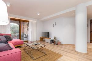 里亚帕德斯Lola's Luxury Apartments的客厅配有粉红色的沙发和桌子