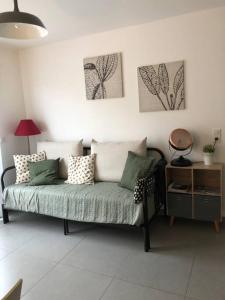 普罗普里亚诺T2 récent climatisé à 100m du port的客厅的沙发,墙上挂有绘画作品