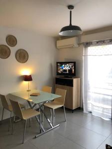 普罗普里亚诺T2 récent climatisé à 100m du port的一间带桌椅和电视的用餐室
