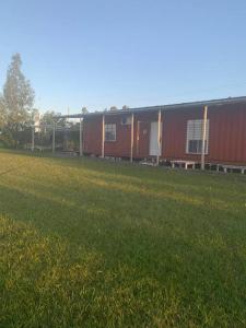 派桑杜Casa Contenedor y espacio verde的草场上一排红色的建筑
