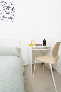 卡塔尼亚Be happy Rooms的一间卧室配有一张床、一张桌子和一把椅子