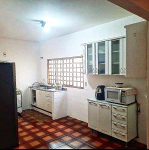 乌贝兰迪亚POUSADA ROSA BRANCA的厨房配有白色橱柜和微波炉