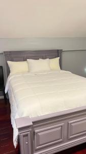 乔治敦Odyssey Suites Loft Apartment的一张白色大床,配有白色床单和枕头