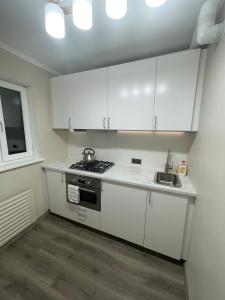 里加Moderns, gaišs, plašs! A++ 3 istabu dzīvoklis的小厨房配有白色橱柜和水槽