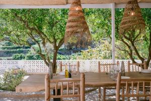 圣胡安包蒂斯塔Valley Club Ibiza - Boutique Agroturismo的花园里种有树木,配有木桌和椅子