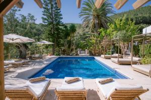 圣胡安包蒂斯塔Valley Club Ibiza - Boutique Agroturismo的一个带躺椅的游泳池以及别墅
