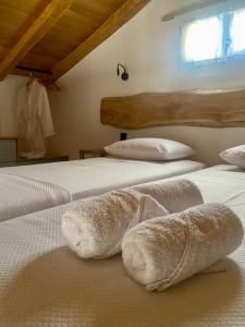 VolissosMY Volissos Apartments的一间卧室配有两张带毛巾的床