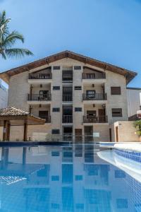 瓜鲁雅Strand Hotel Guarujá Frente Mar的大楼前设有游泳池的酒店