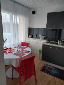 贝尔蒙叙尔洛桑Beau studio avec terrasse et vue EXCLUSIVEMENT POUR NON FUMEURS的厨房配有红色椅子和水槽